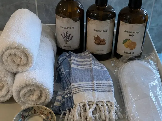 Rulo havlular, mavi peştemal ve aromaterapi yağları — Güzelce, Masaj Salonun